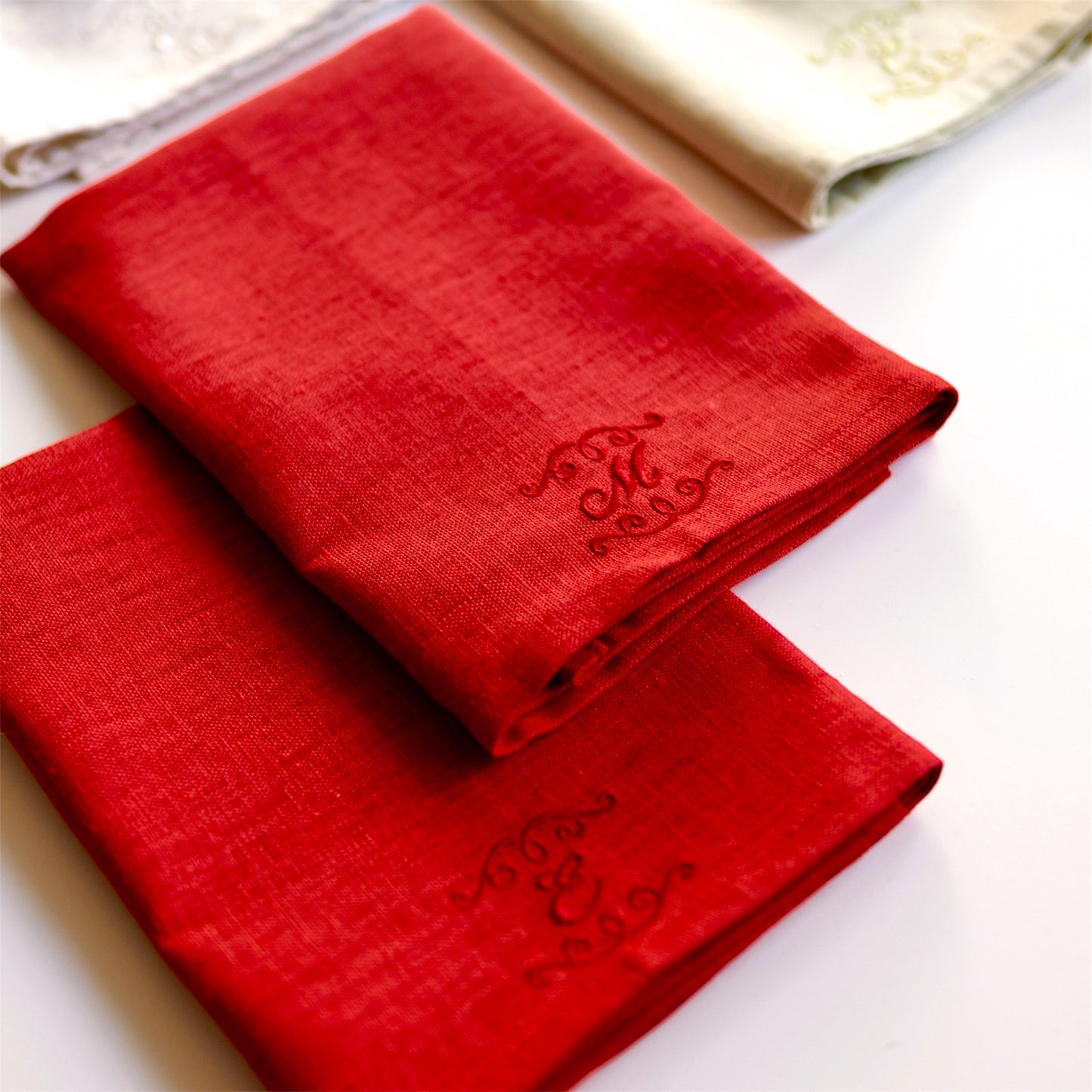 Röda linneservetter med broderade initialer och dekor i rött