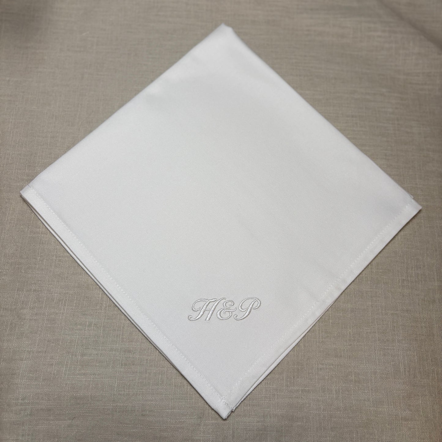 Klassisk lyxig vit tygservett av tät och fin bomull. Monogram broderat med vit brodyrtråd. H&P i kursiv stil i nedre hörnet.