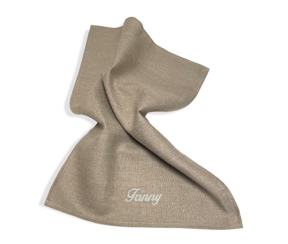 Linnehandduk med broderat namn. Handduken är av 100% linne och broderiet utförs på beställning. Namnet Fanny är broderat med vit broderitråd.