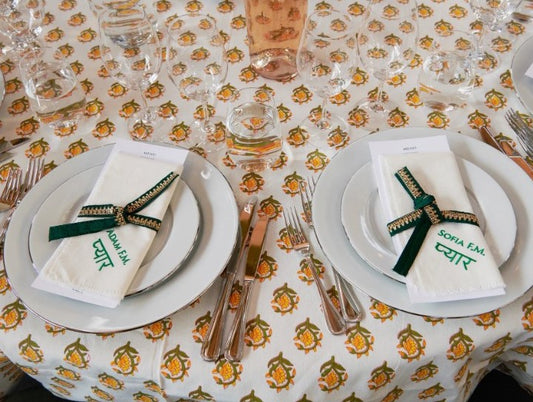 Dukning vid bröllop färgglad duk och broderade servetter. Vita servetter med grön brodyr gästernas namn.