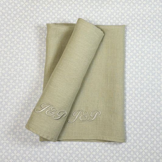 Blek linblomsgrön tygservett av linne med broderade initialer i samma nyans: J&P. 