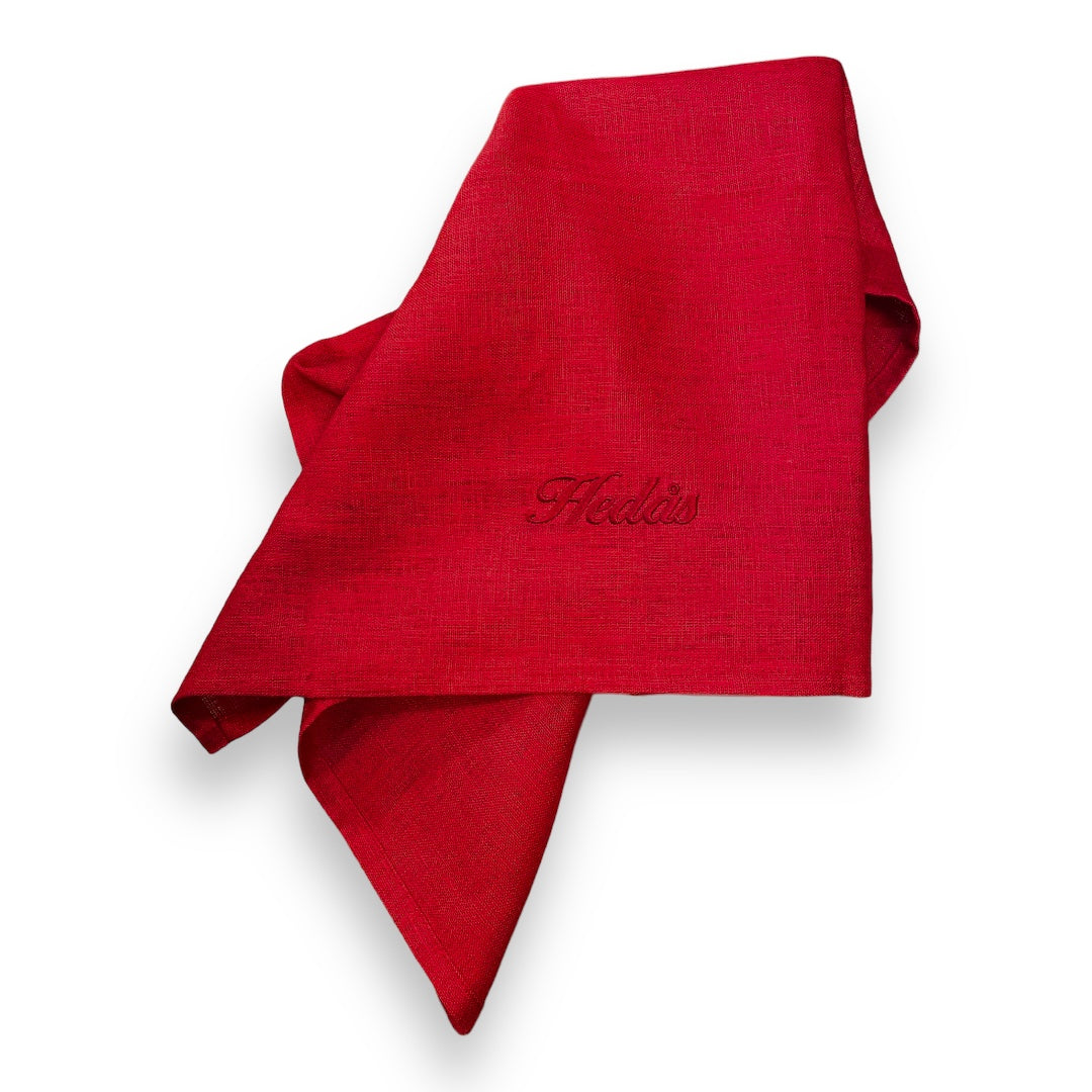 Linnehandduk med broderat namn. Handduken är röd, av 100% linne och broderiet utförs på beställning. Hedås med röd brodyr.
