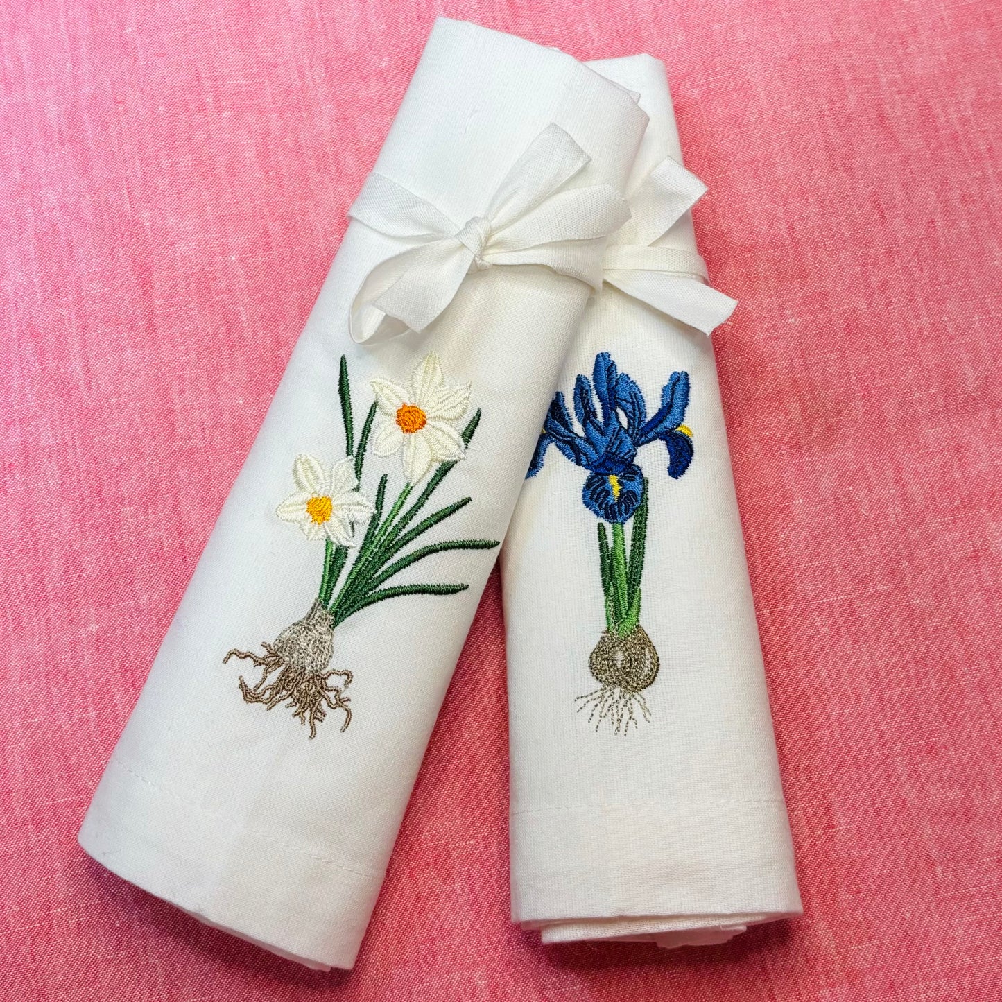 Linneservetter med två olika vårblommor vårlökar broderade. Blå iris, vit pingstlilja. Blommorna har sina lökar med. 