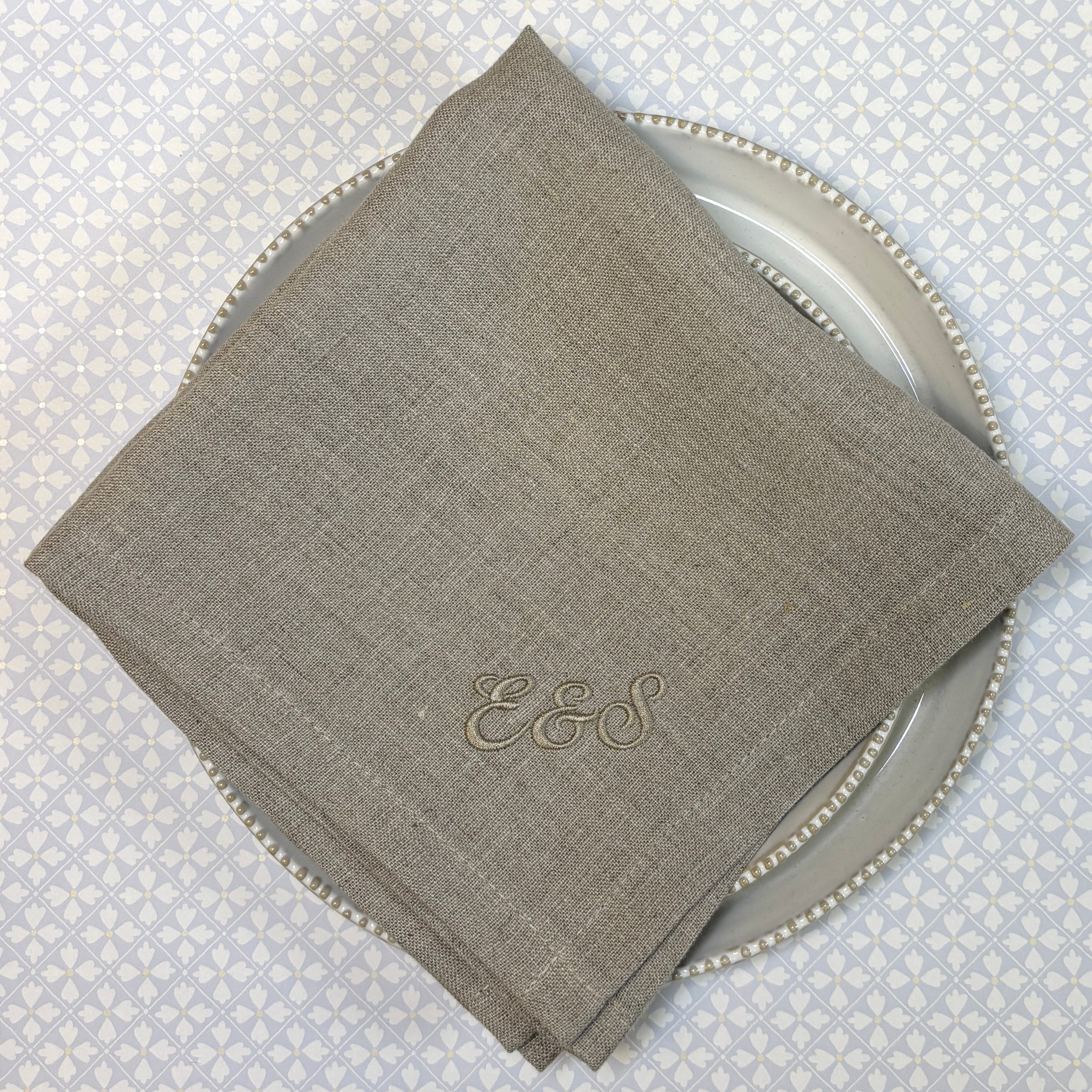tygservetter av linne med broderade initialer namn eller monogram diagonalt i nedre hörnet. naturfärg linnefärg.