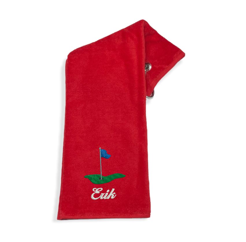 Röd golfhandduk med namn broderat. Bra present till den som golfar. Motivet golf green med flagga. Broderas på beställning hos Gyllene Tråden.